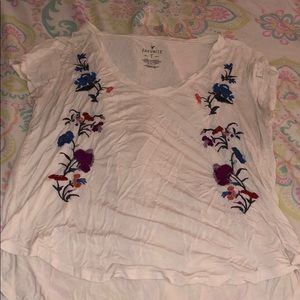 white flowy v-neck shirt with flower on front